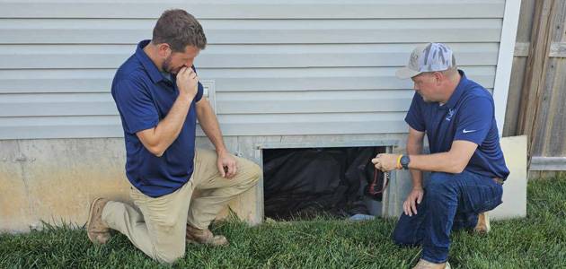 Two Men Inspecting a Crawl Space