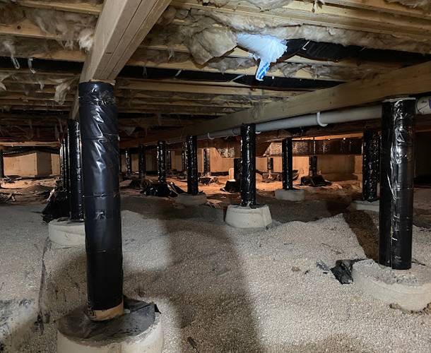 a basement with black poles and white sand