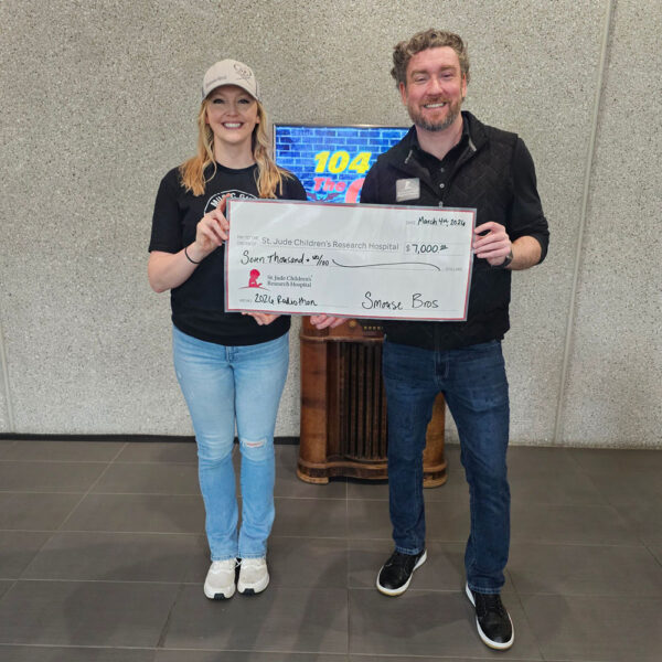 Two people holding donation check