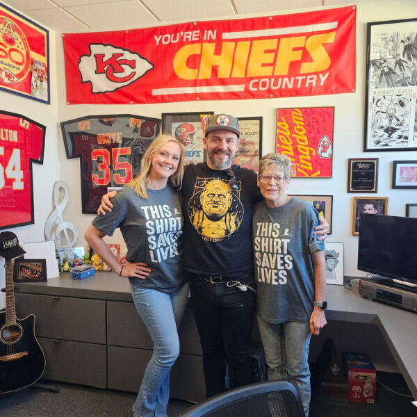 Three people in themed shirts smiling
