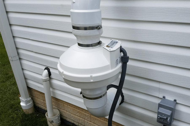 White radon mitigation system on wall